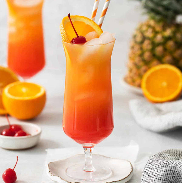 Pineapple Tequila Sunrise cocktail with fresh cherry and orange garnish with link to recipe