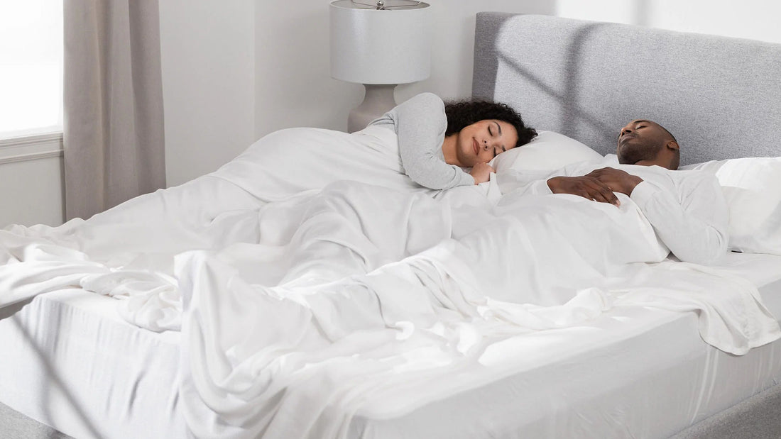 Couple sleeping peacefully Hush Iced Sheets in white color.