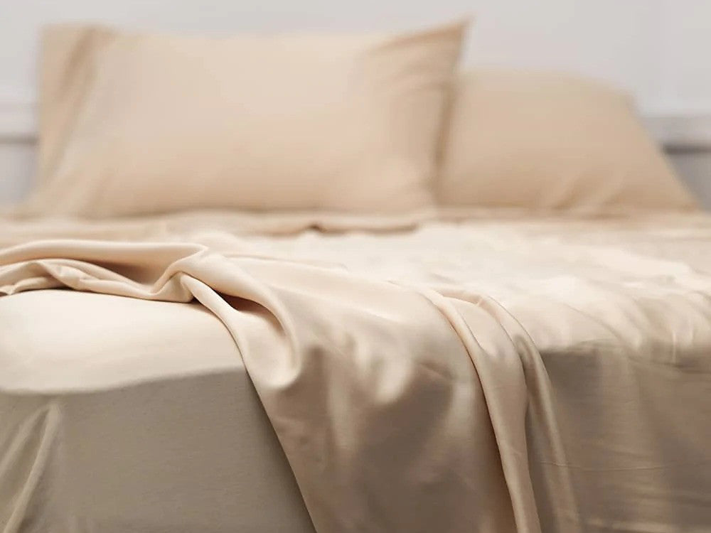 A bed with Hush Iced Bamboo Cooling sheet and pillowcase set in iced latte color.