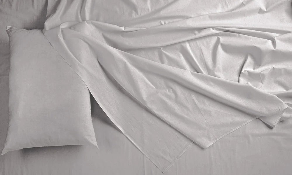 A set of Puffy Bamboo Bed sheets draped across a mattress and a pillow.