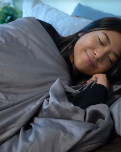 how to increase deep sleep: woman uses a weighted blanket