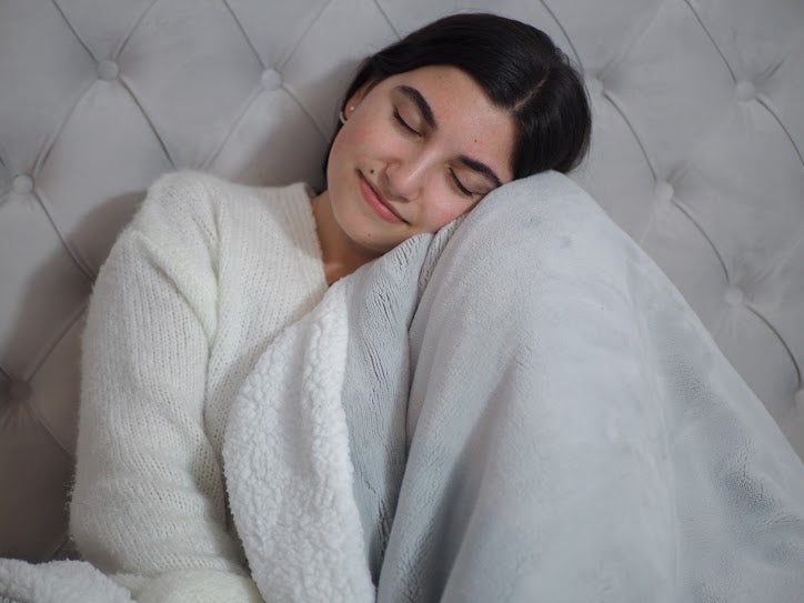 night routine: Woman hugging a blanket with her eyes closed