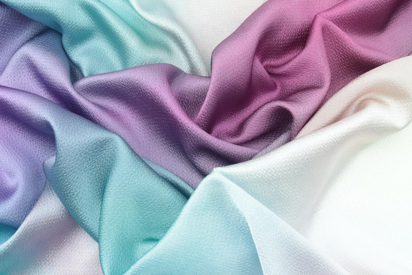 A textile showing a beautiful colorful gradient from blue green to purple color.