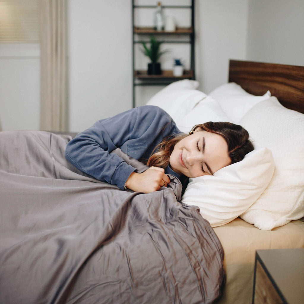 Smiling woman sleeping with a weighted blanket