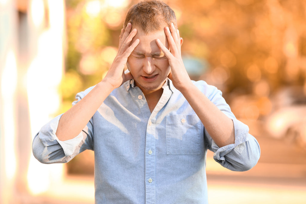sensory overload anxiety: stressed man holding his head
