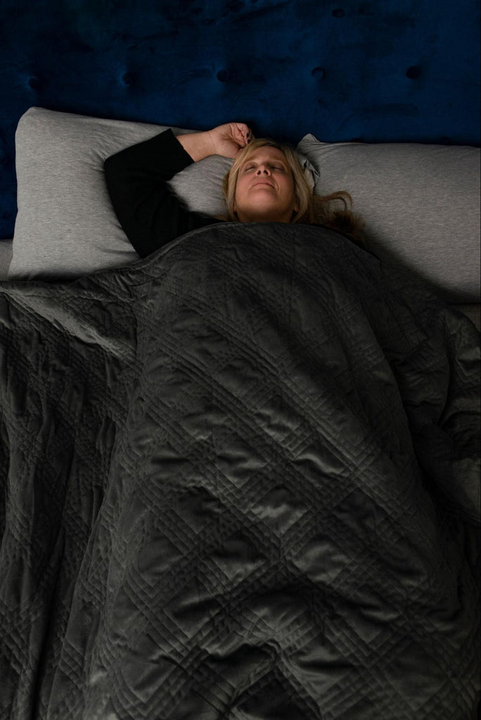 Woman sleeping in bed with a weighted blanket