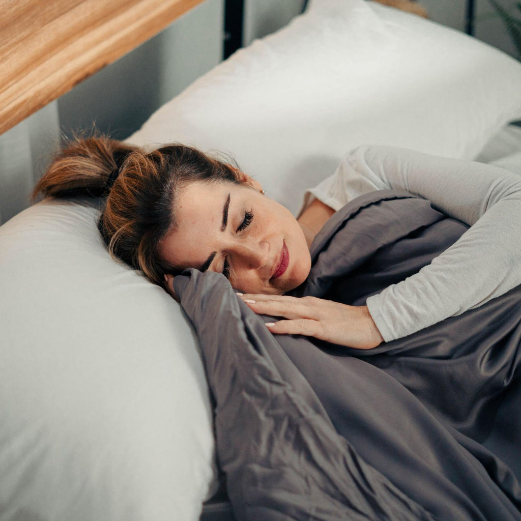 Woman sleeping in bed with a weighted blanket