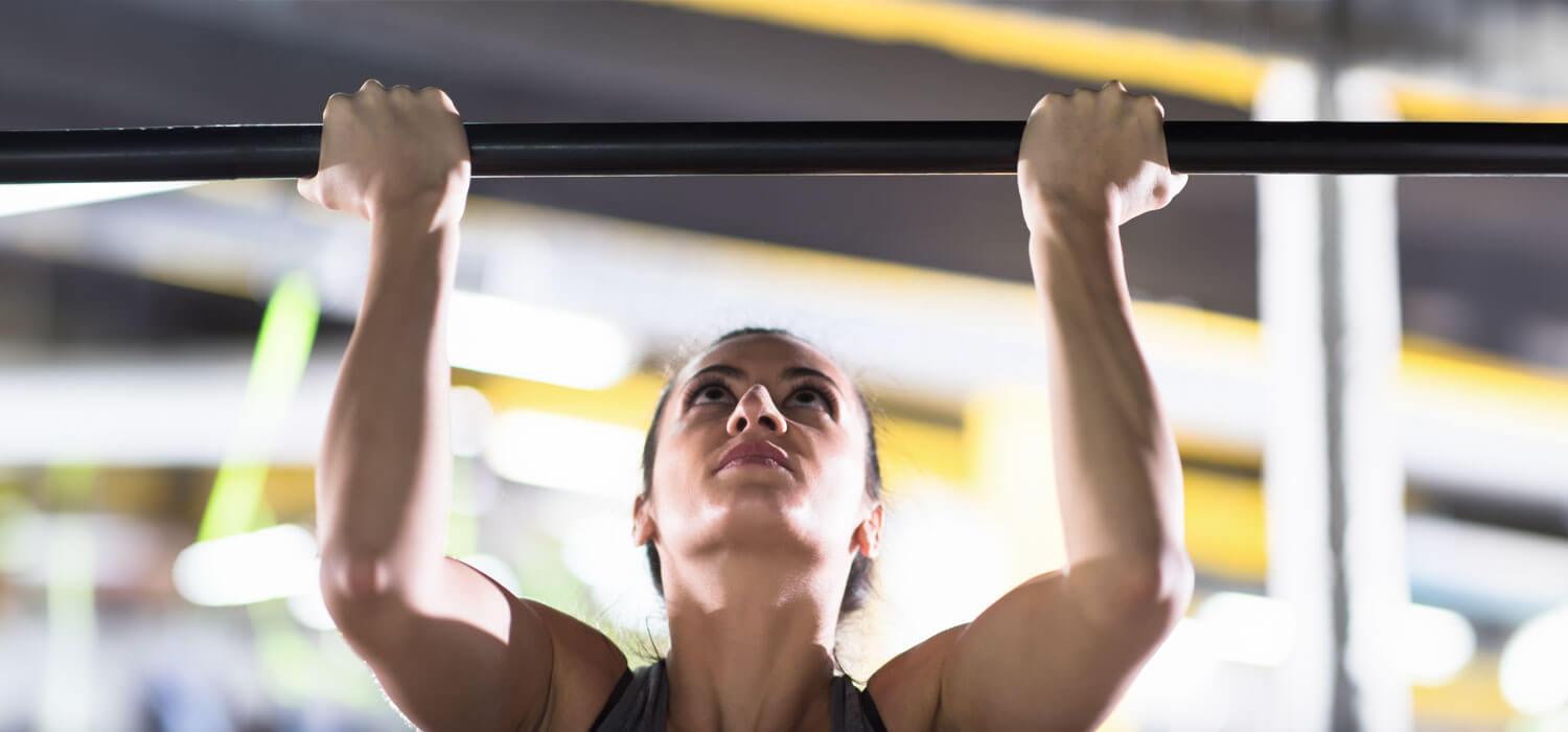 Woman doing pull ups on a pull up bar