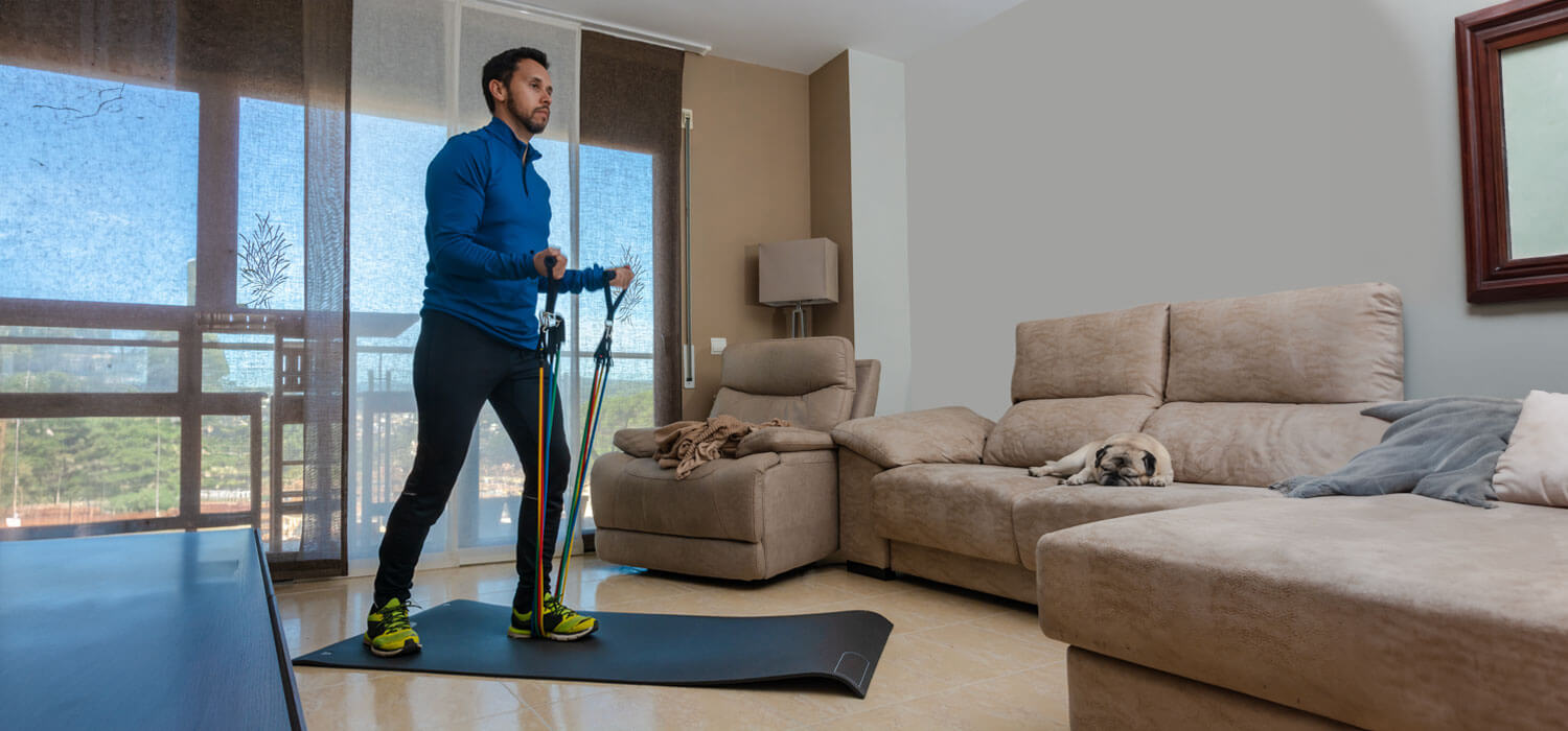 Man using resistance bands at home in living room