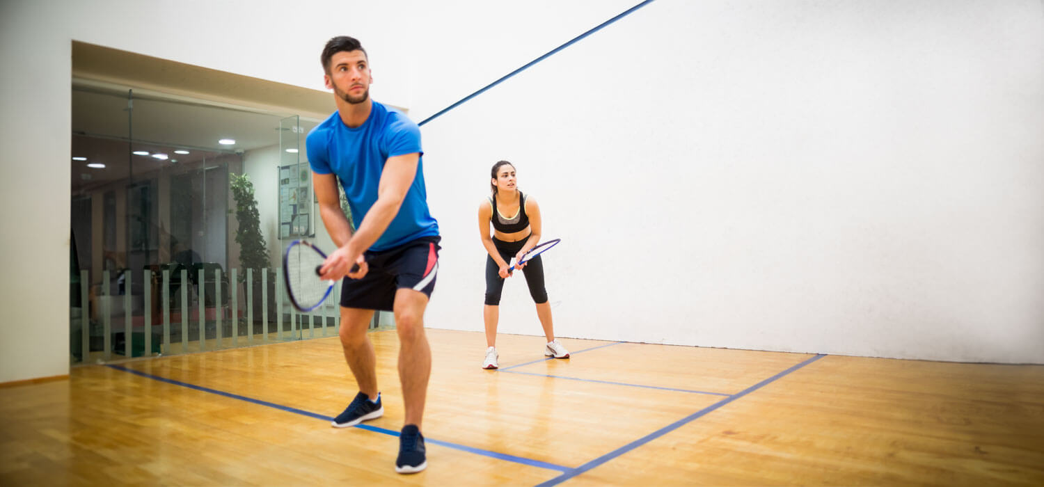Man and woman playing squash on a squash court
