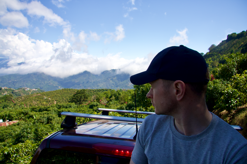 Hasbean eCommerce Manager Chris Glover-Price rides in the back of a pickup truck while viewing coffee farms in Leon Cortes, Costa Rica