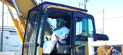 Demolition crane operator wears respiratory protection to reduce asbestos exposure on the job in Detroit