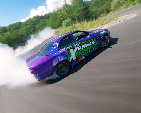 Purple Toyota Chaser drifting on a race track in Japan.