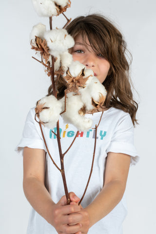 Girl holding cotton plant in Mightly shirt