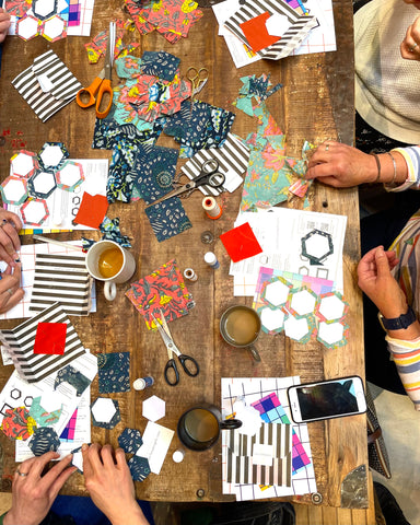 looking down on a table of people sewing