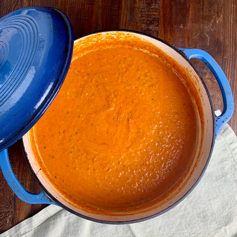 pot of creamy basil tomato soup in a blue dutch oven
