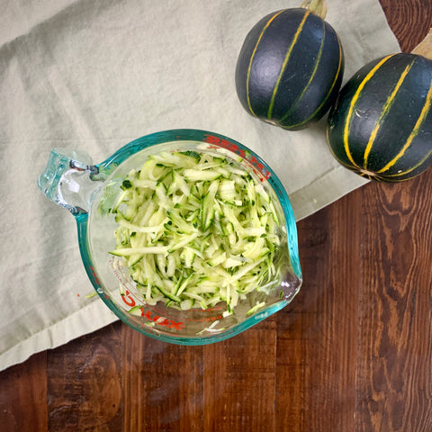 shredded zucchini in a measuring cup for zucchini bread recipe