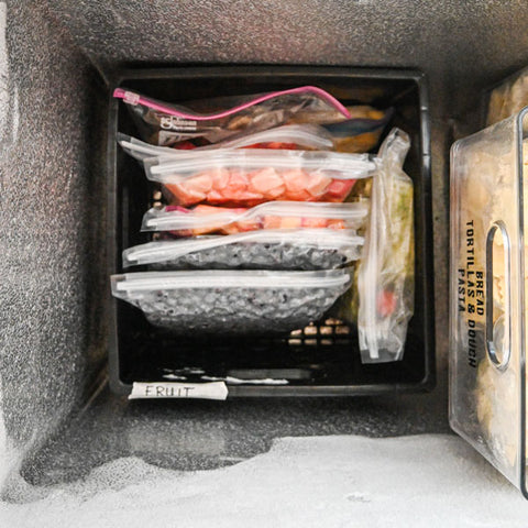Milk crate in bottom of deep chest freezer.