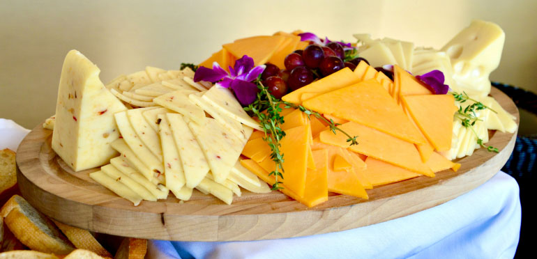 Tray filled with slices of various cheeses.