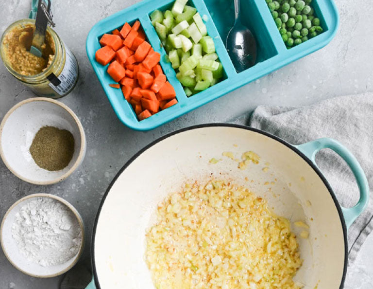 Bowls filled with spices, Souper Cubes tray with various diced vegetables, and a bowl with a mixture of ingredients.