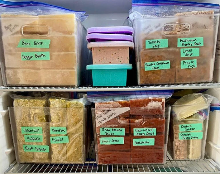 Blocks of labelled frozen food in a freezer.