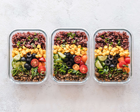 Three glass containers laid out with food prepared in each one. 