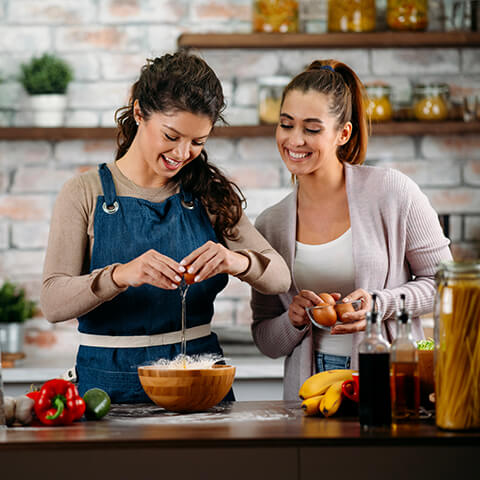 two friends cooking happily together