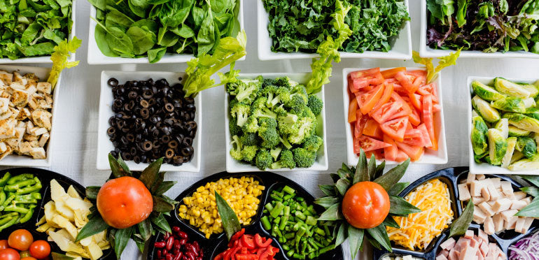 Various leafy greens and vegetables prepared and displayed in individual bowls.