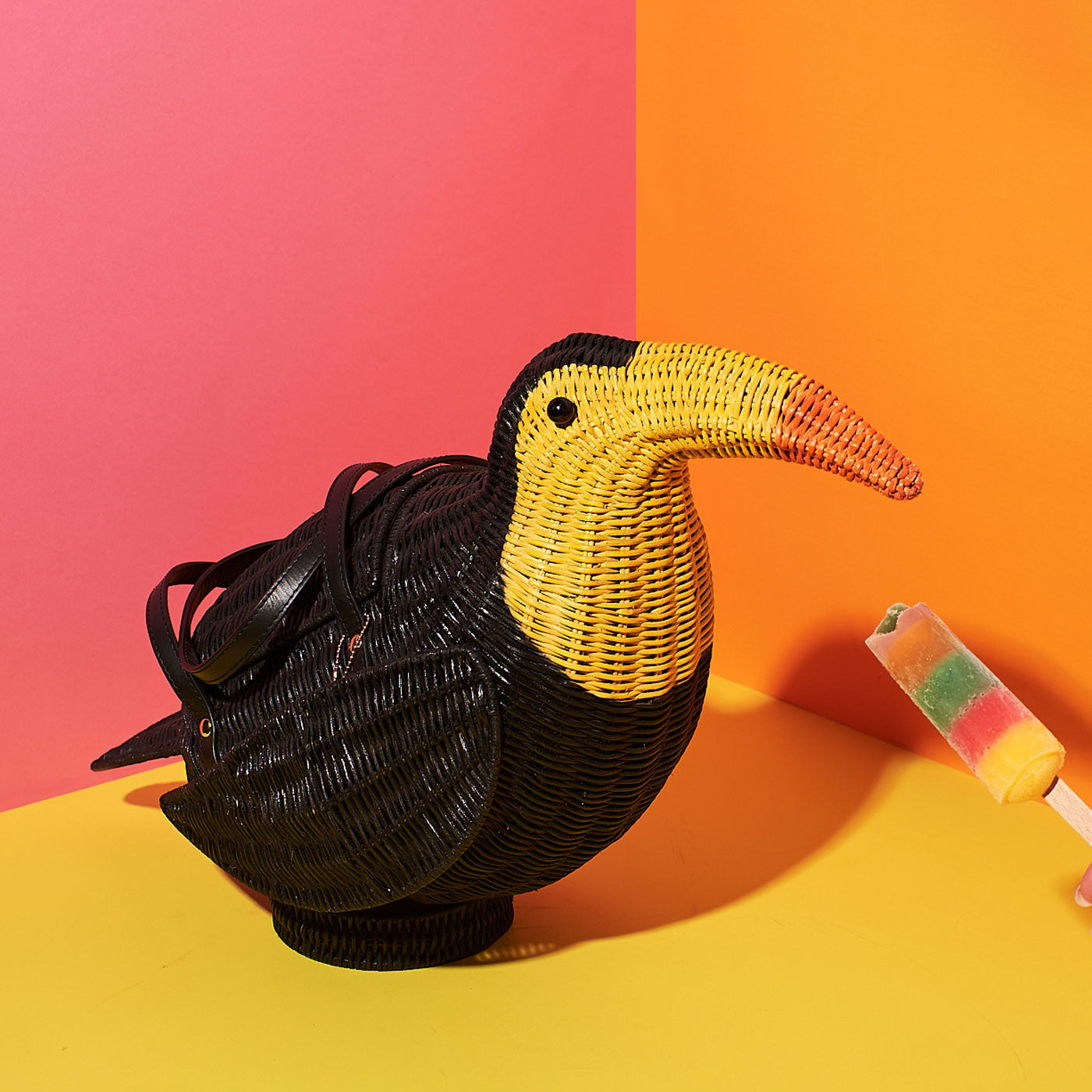 Wicker Darling's Tallulah the Toucan bag on a colourful background