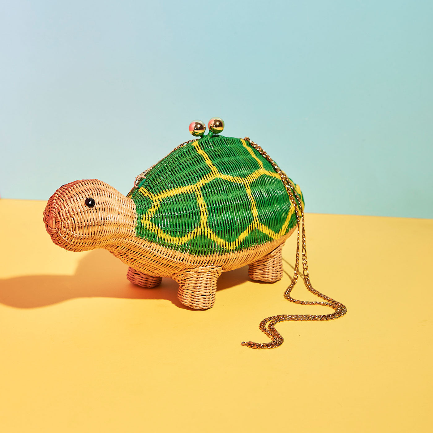 Wicker Darling's Shelby the Turtle Clutch on a colourful background