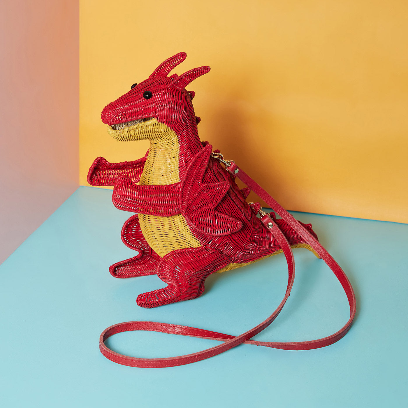 Wicker Darling's Rhys the Red dragon purse on a colourful background