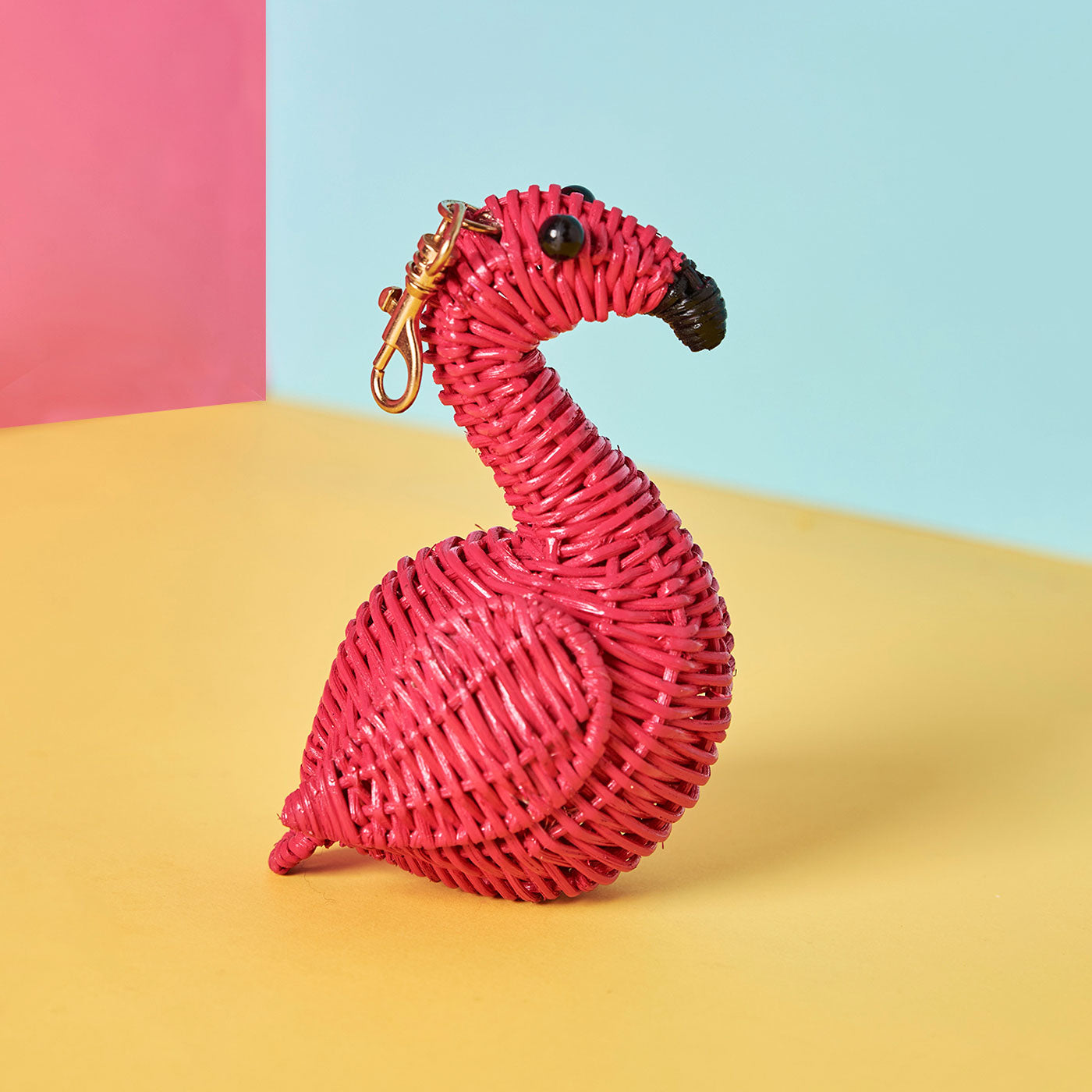Wicker Darling's flamingo bag charm on a colourful background