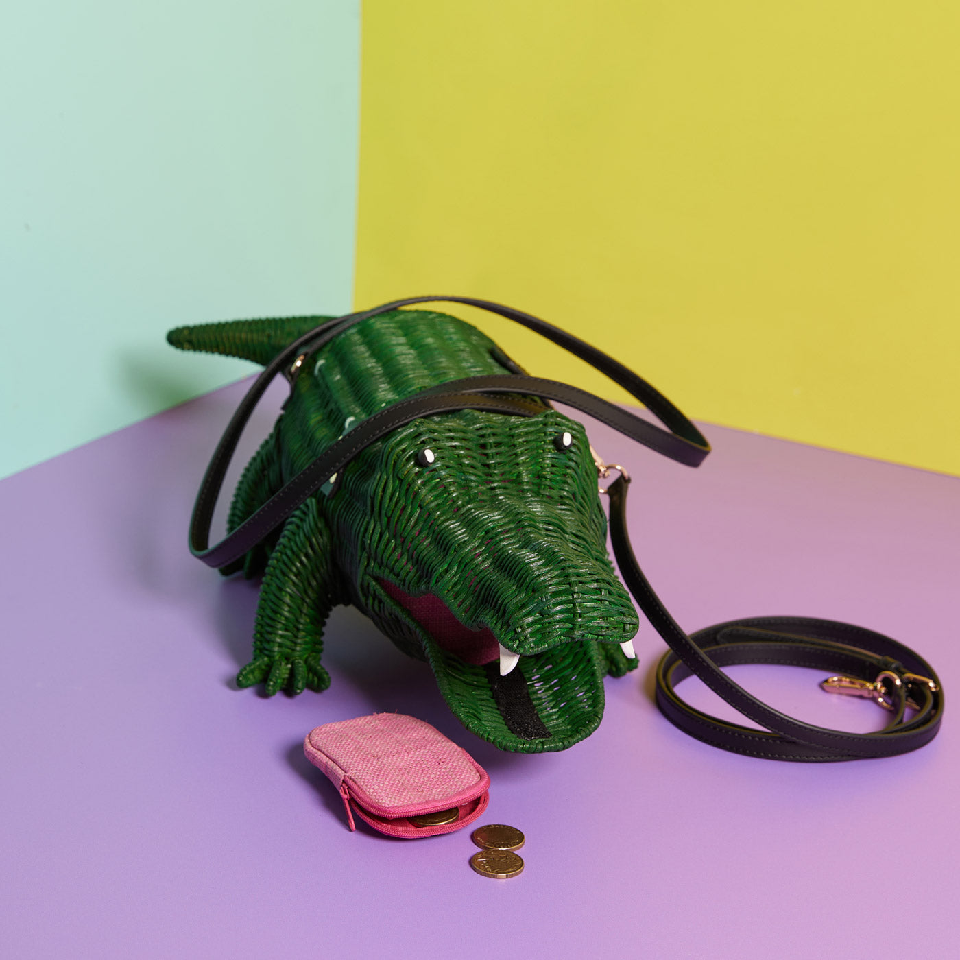 Wicker Darling's dark green Crocogater with pink purse on a colourful background