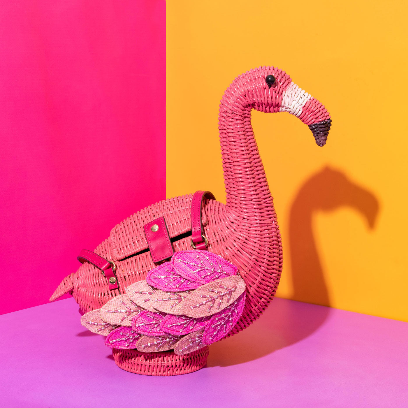 Annie the Anniversary Flamingo Wicker Darling bag on a colourful background