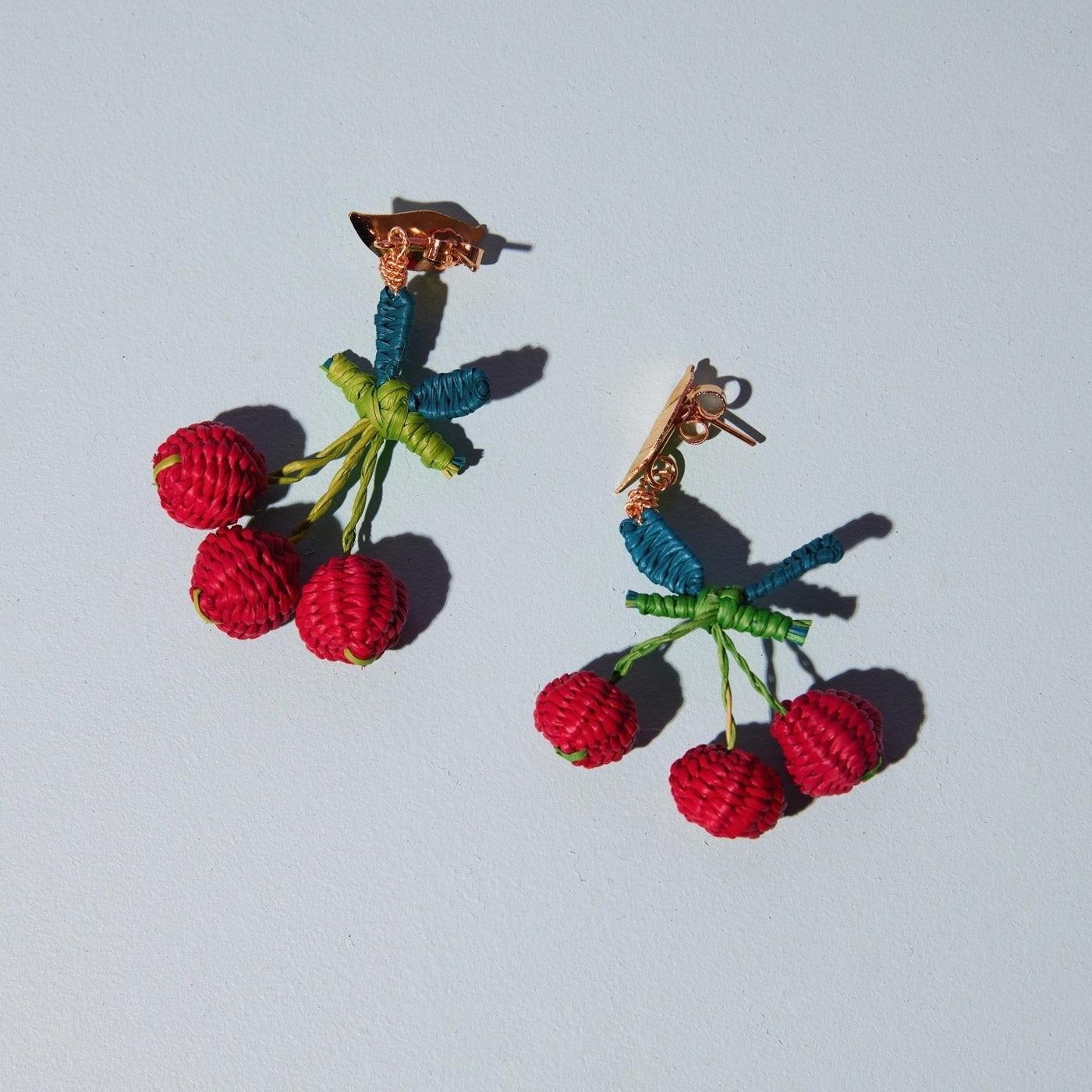 Wicker Darling's cherry earrings on a gray background