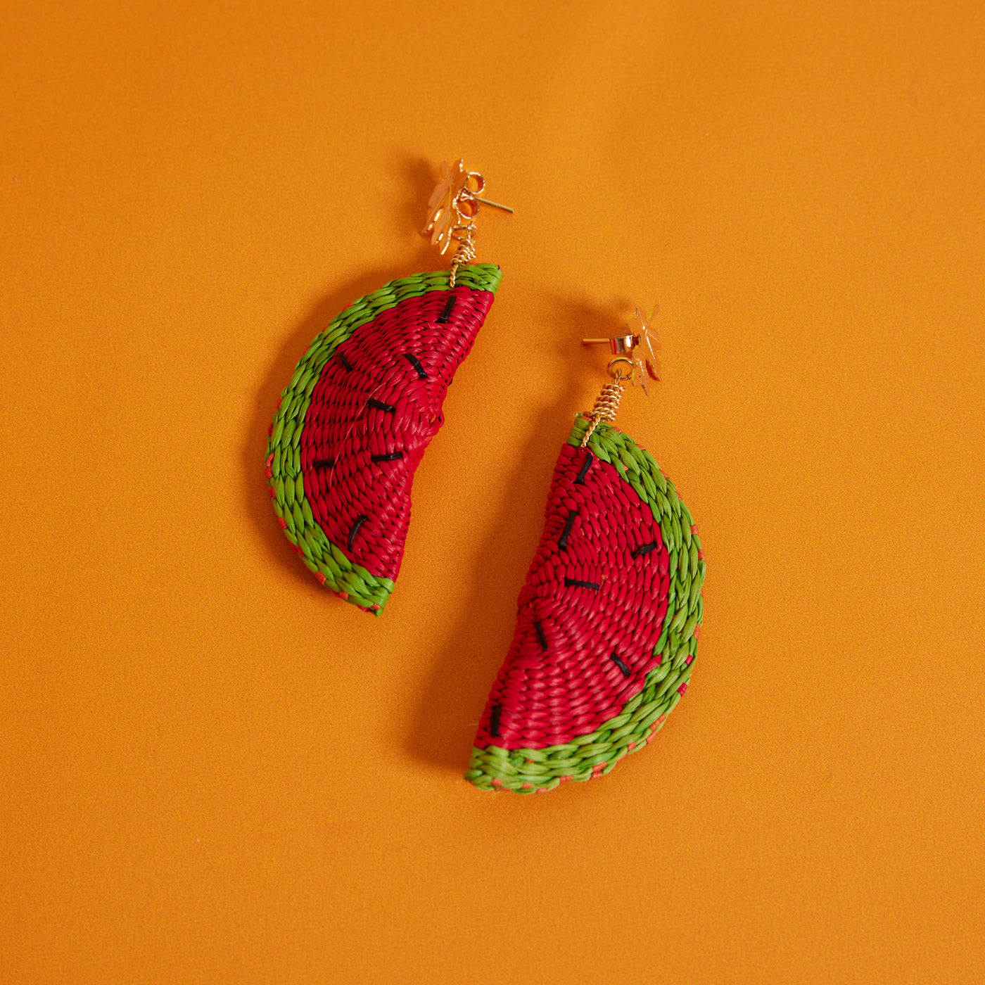 Watermelon earrings from Wicker Darling on an orange background