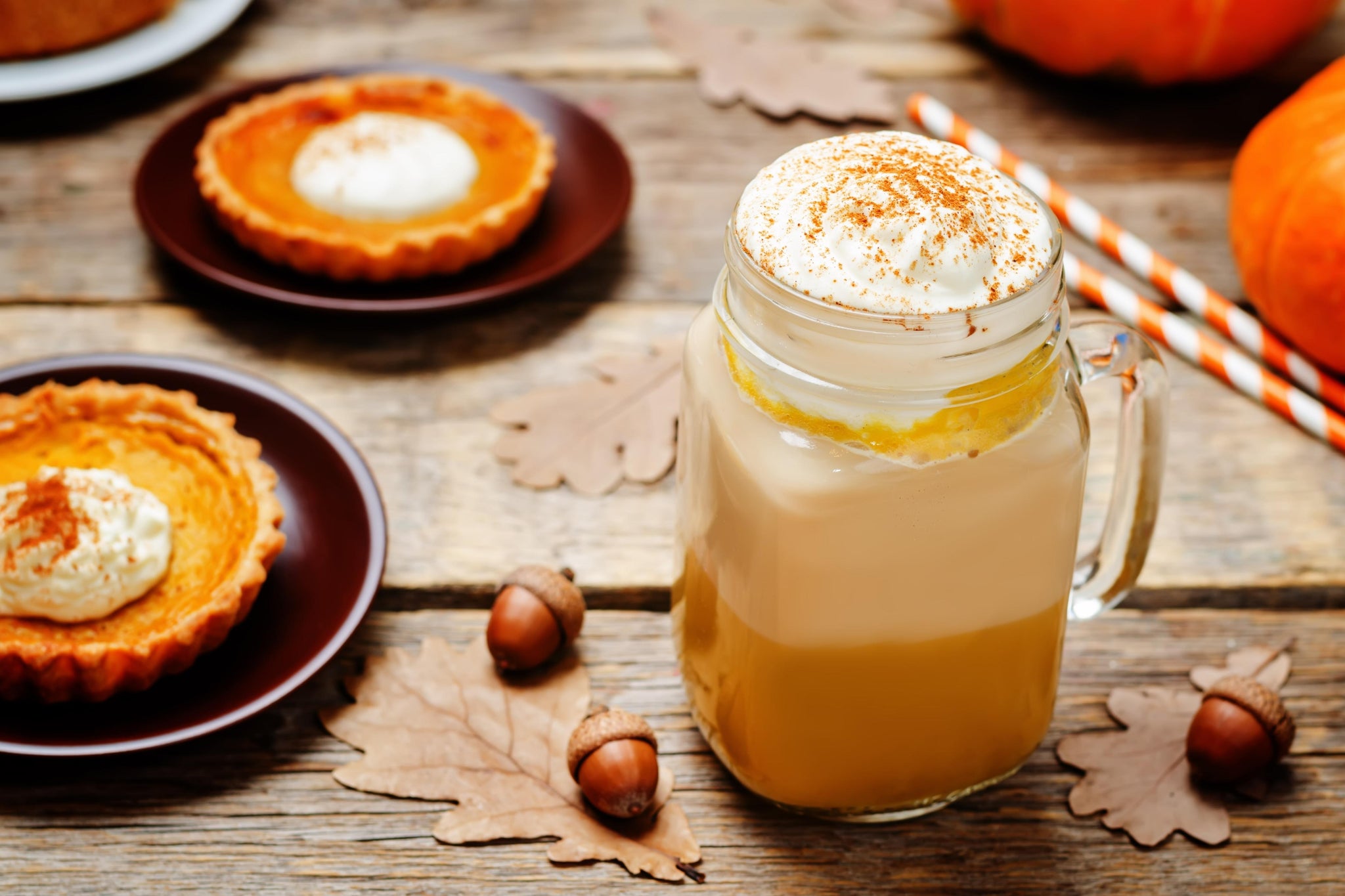 Pumpkin spice latte and pumpkin pie on a Halloween themed table