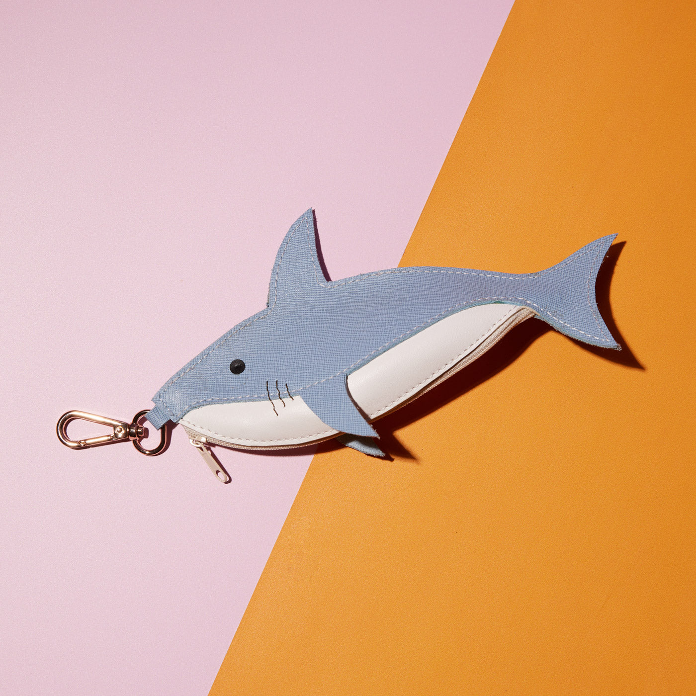 Wicker Darling's Caesar the shark coin purse on a colourful background