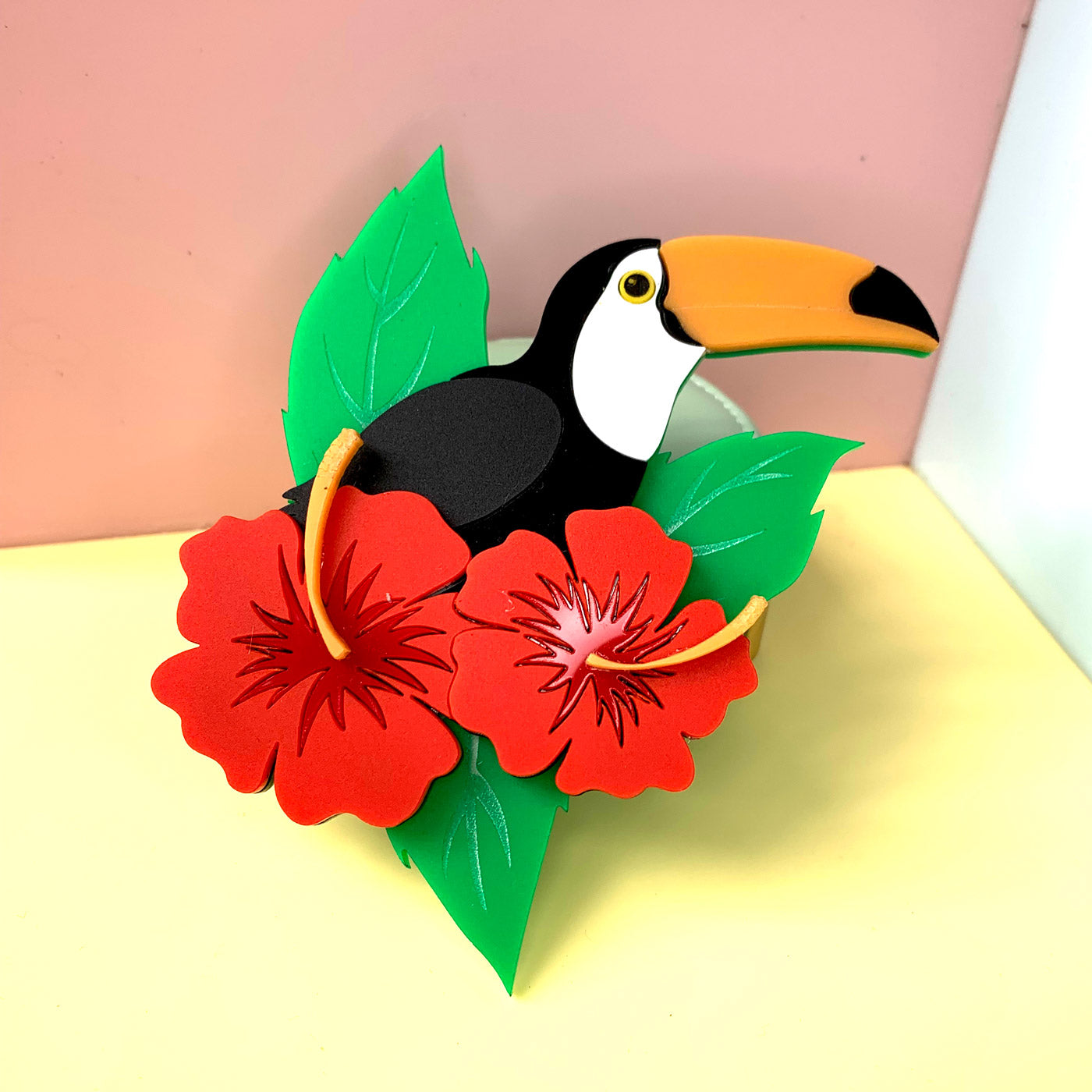Wicker Darling's Tucano the toucan brooch on a colourful background
