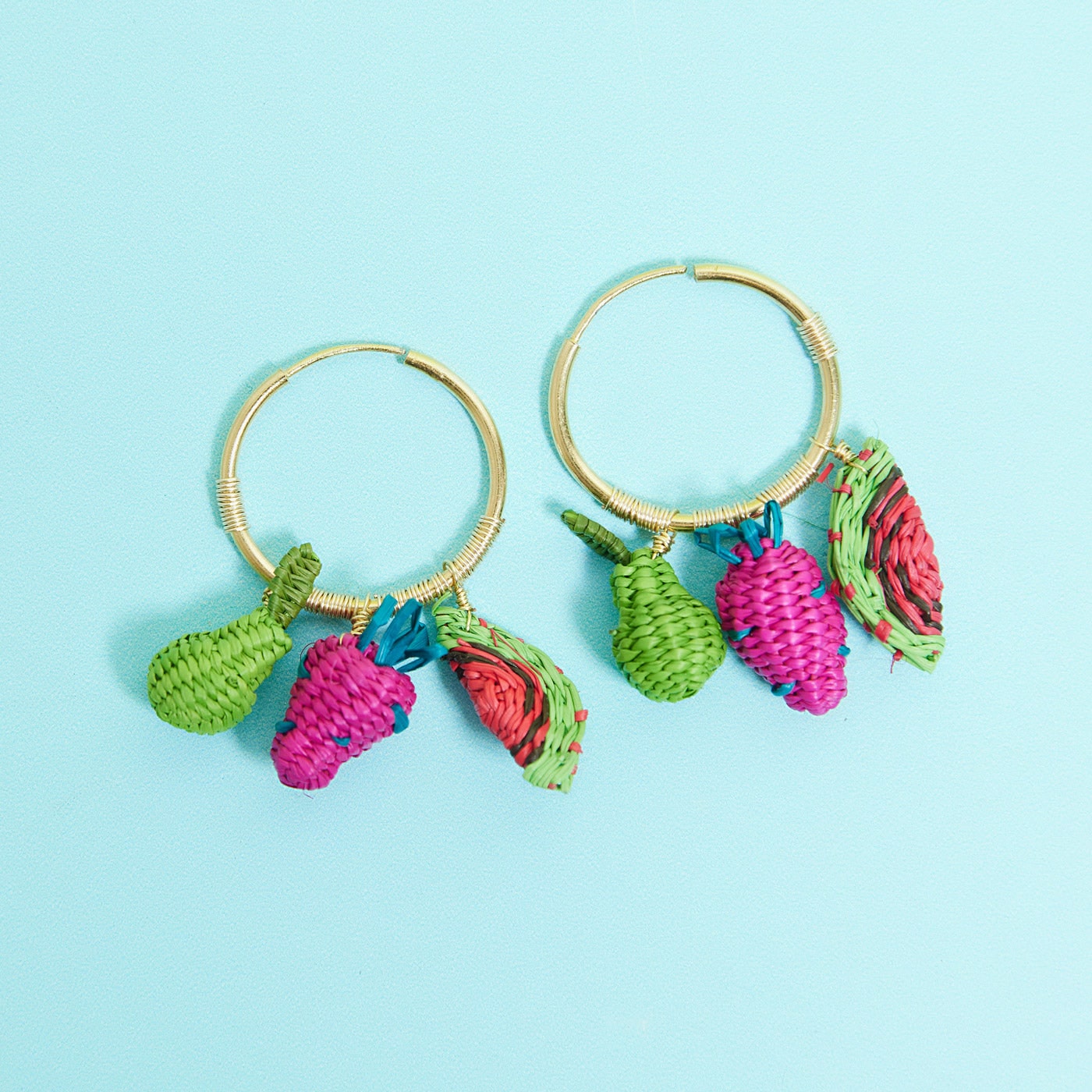 Wicker Darling's Fruit salad earrings on a bright blue background