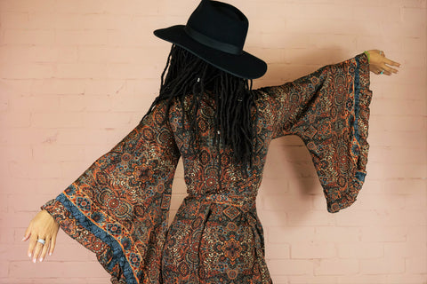 back view sleeve detail model wears venus mini wrap dress rust and jet black moroccan tile print by all about audrey