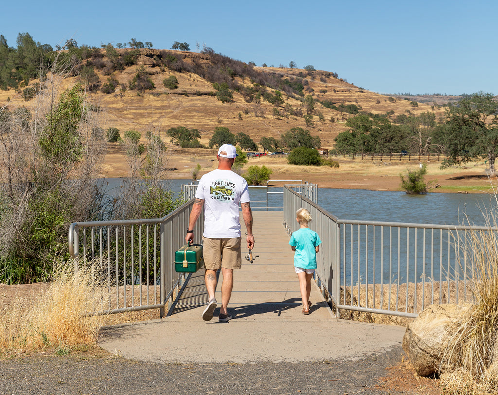 man and his daughter walking out on the dock at horseshoe lake in bidwell park, chico, california