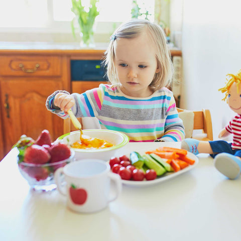 child eating fruits and vegetables at the table