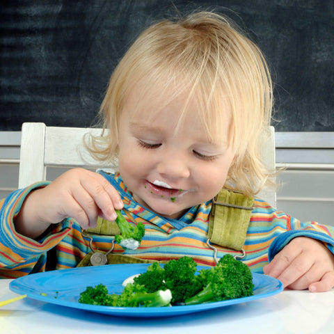 child eating broccoli