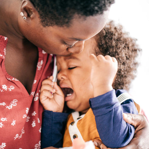 child having a tantrum next to mom