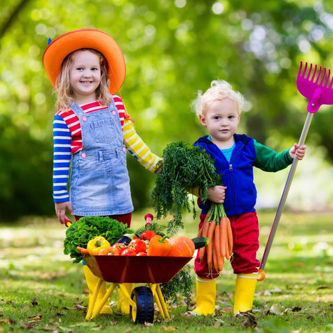 kids with fresh vegetables in a wheelbarrow