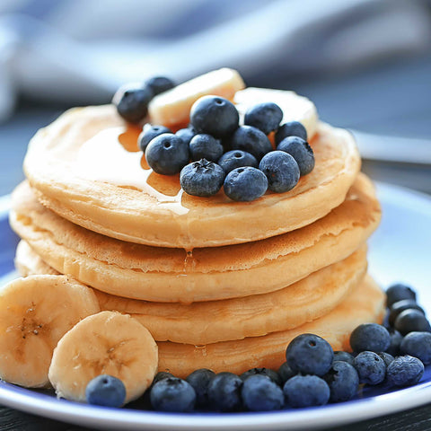 stack of pancakes with blueberries and banana slices