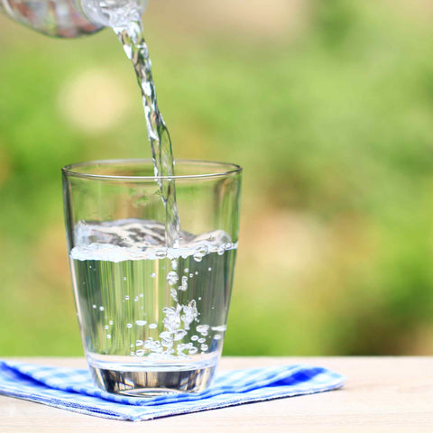 water being poured into a glass cup