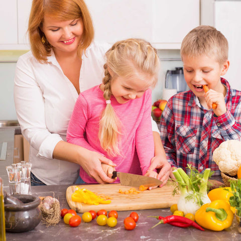 mom and kids cutting vegetables in the kitchen