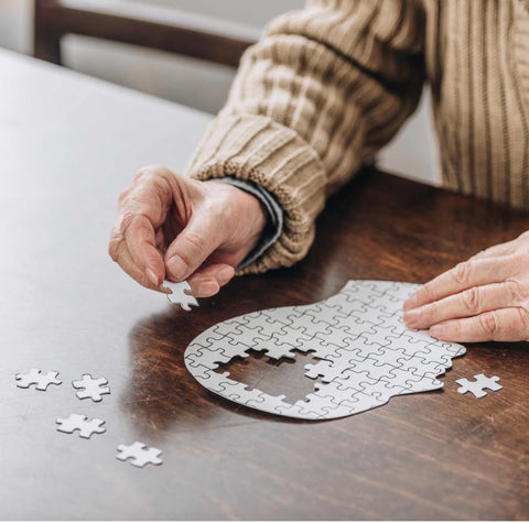 man completing a puzzle of head